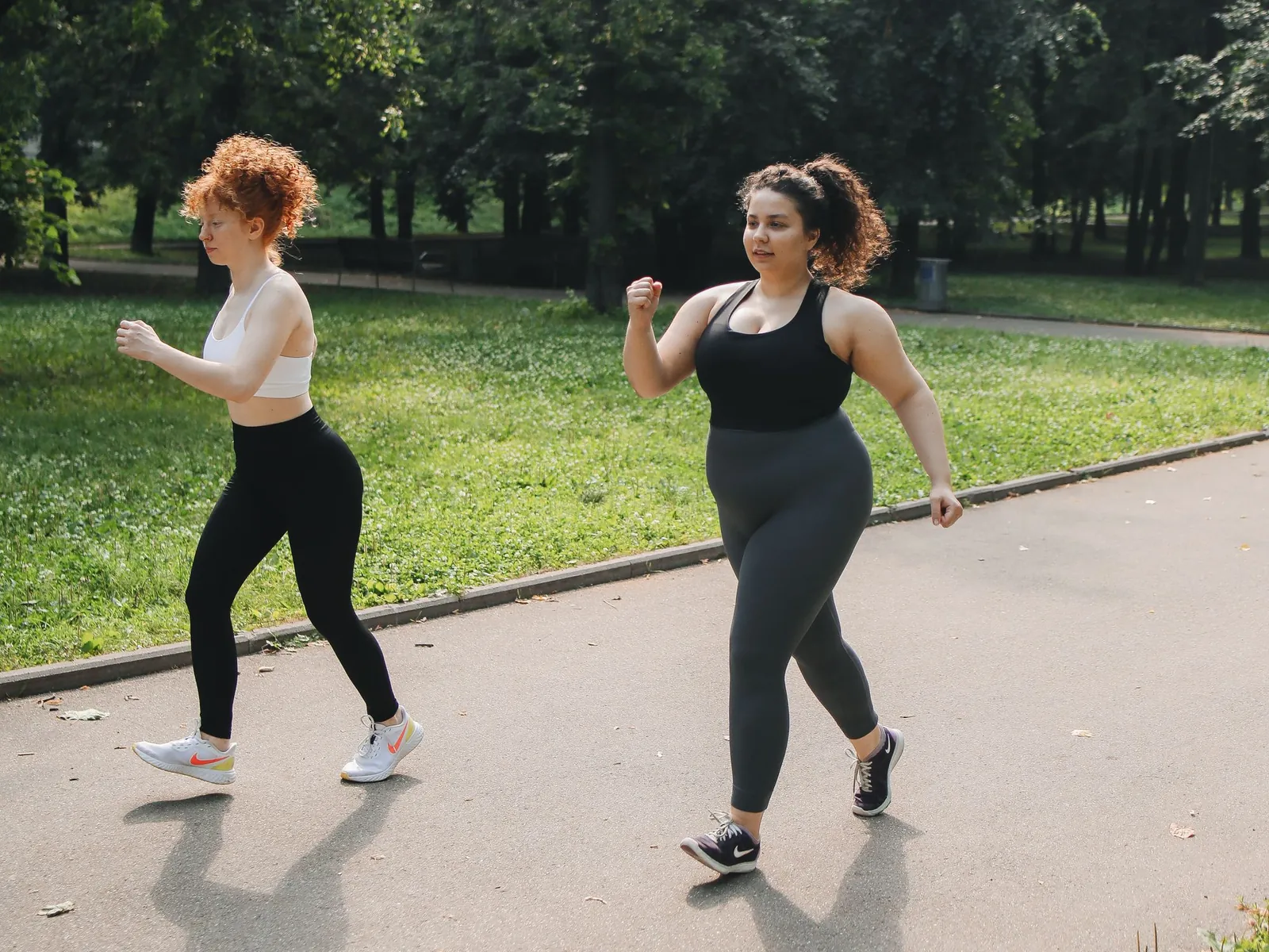 Two women power walking in a park